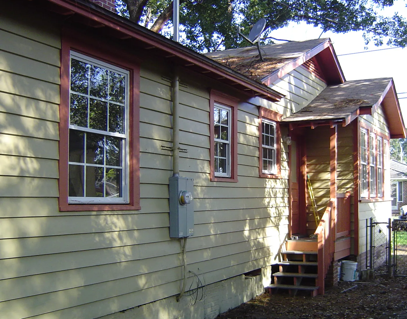 Light green bungalow exterior with covered entry porch and side driveway