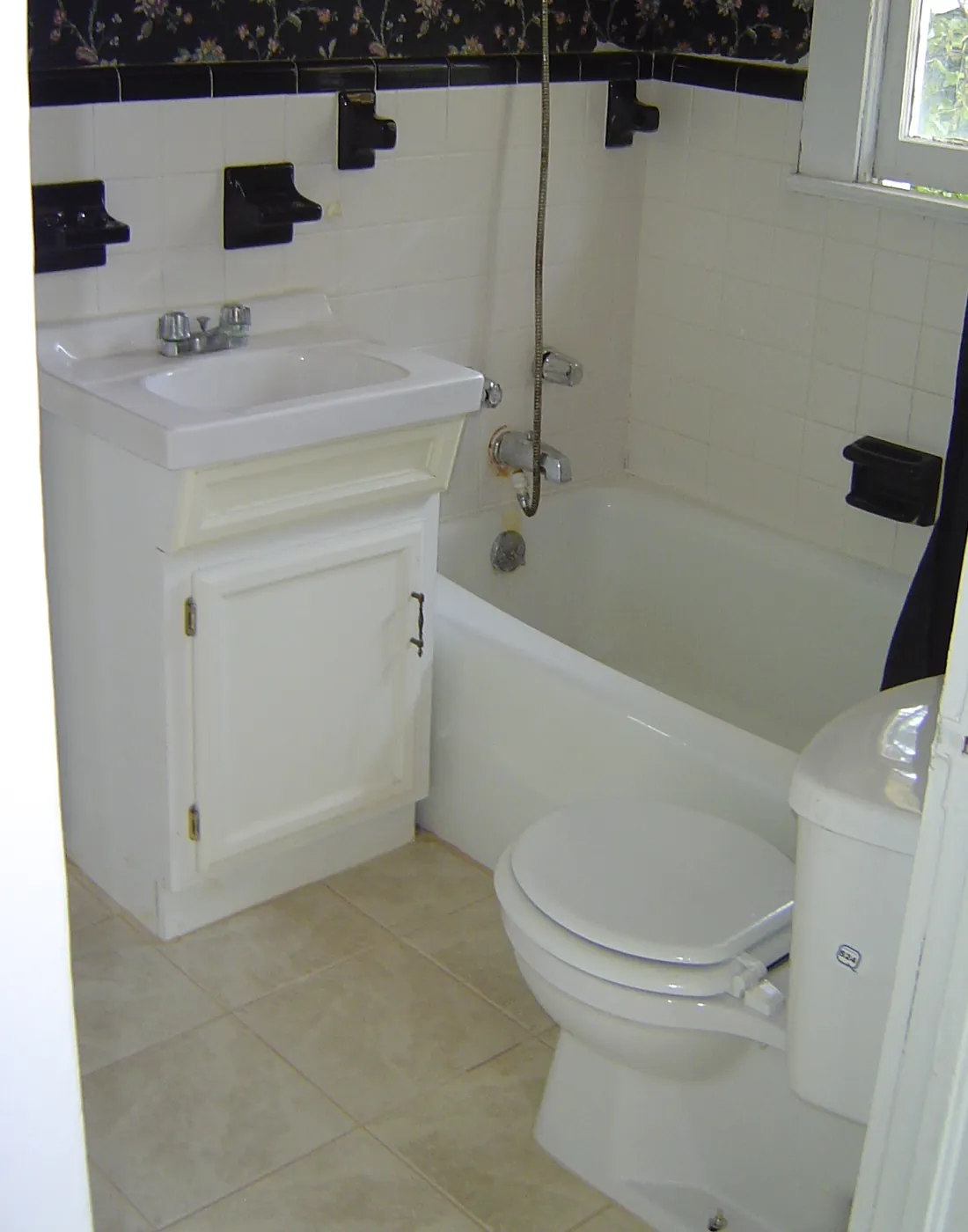 Finished bathroom with tiled tub, new vanity and dark decorative wall border