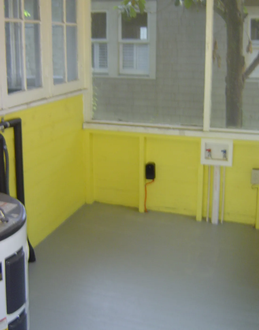 Bright enclosed sunroom porch with yellow walls and banks of windows