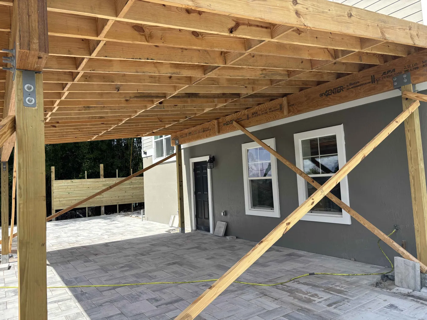 Cabana roof framing and temporary diagonal braces above the unfinished patio