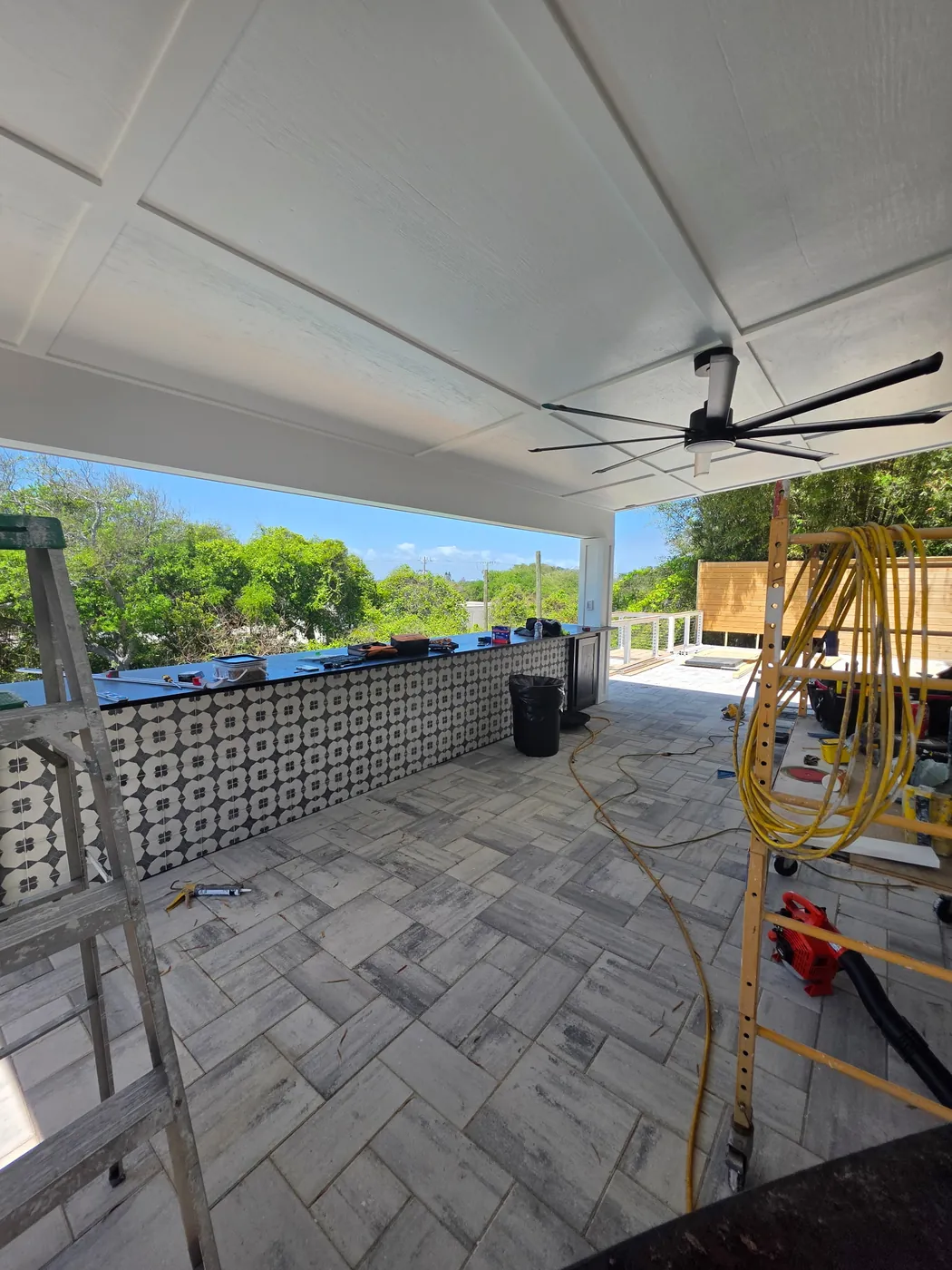 Cabana finishing in progress around the outdoor bar with tools and materials on the patio