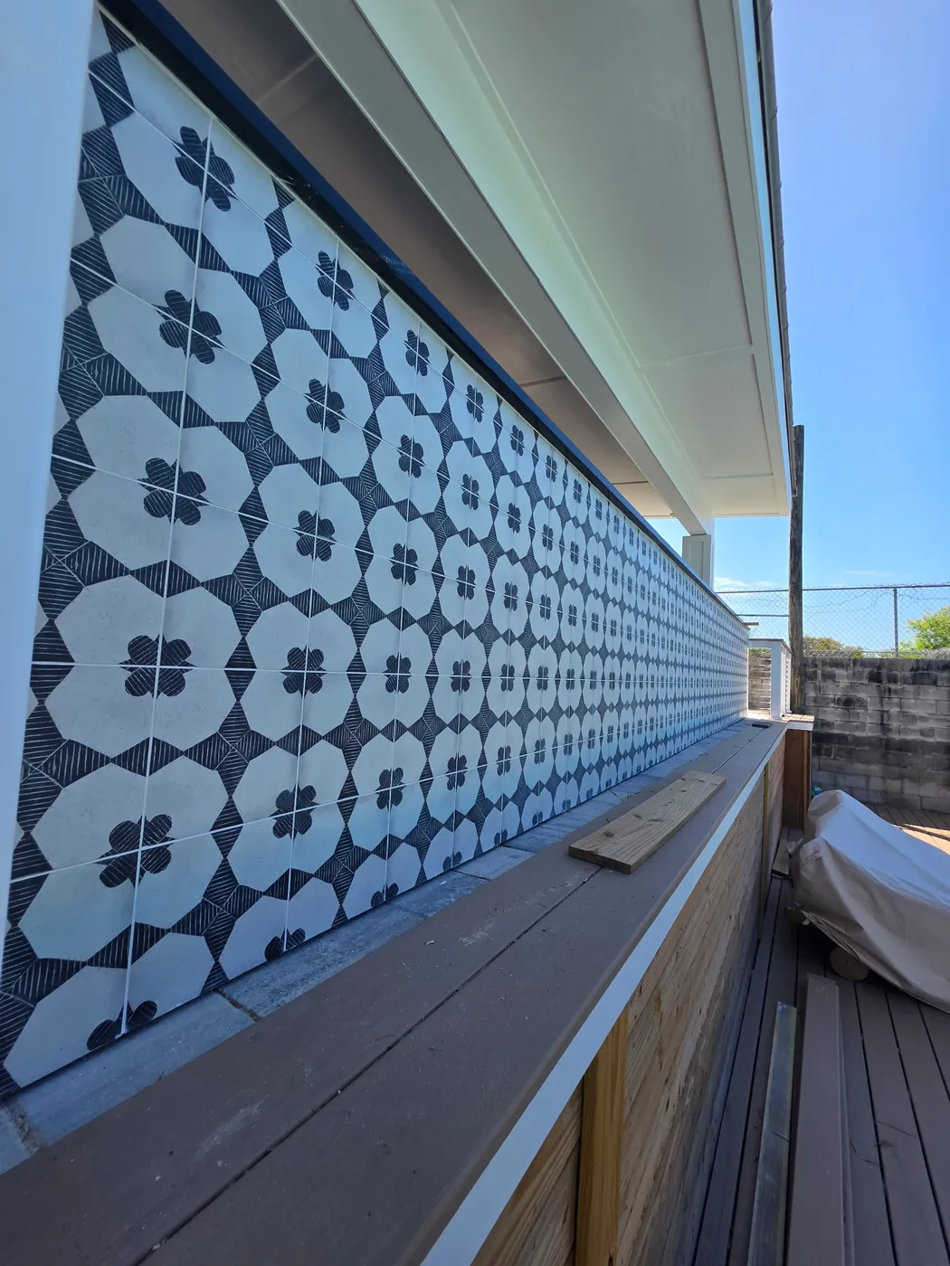 Close view of patterned bar panels being fitted beneath a dark countertop