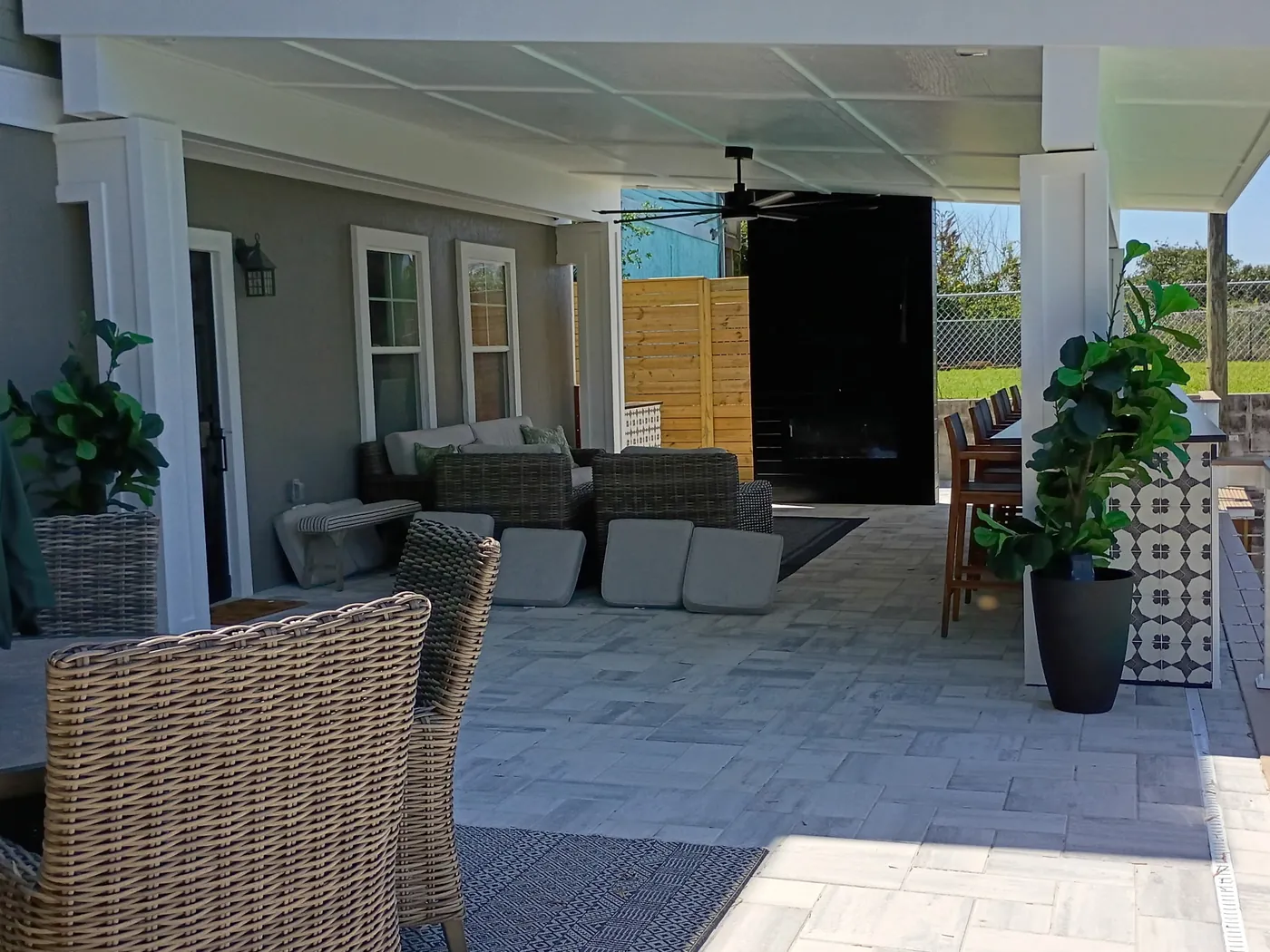 Finished cabana patio with woven seating, paver floor, paneled ceiling and outdoor bar