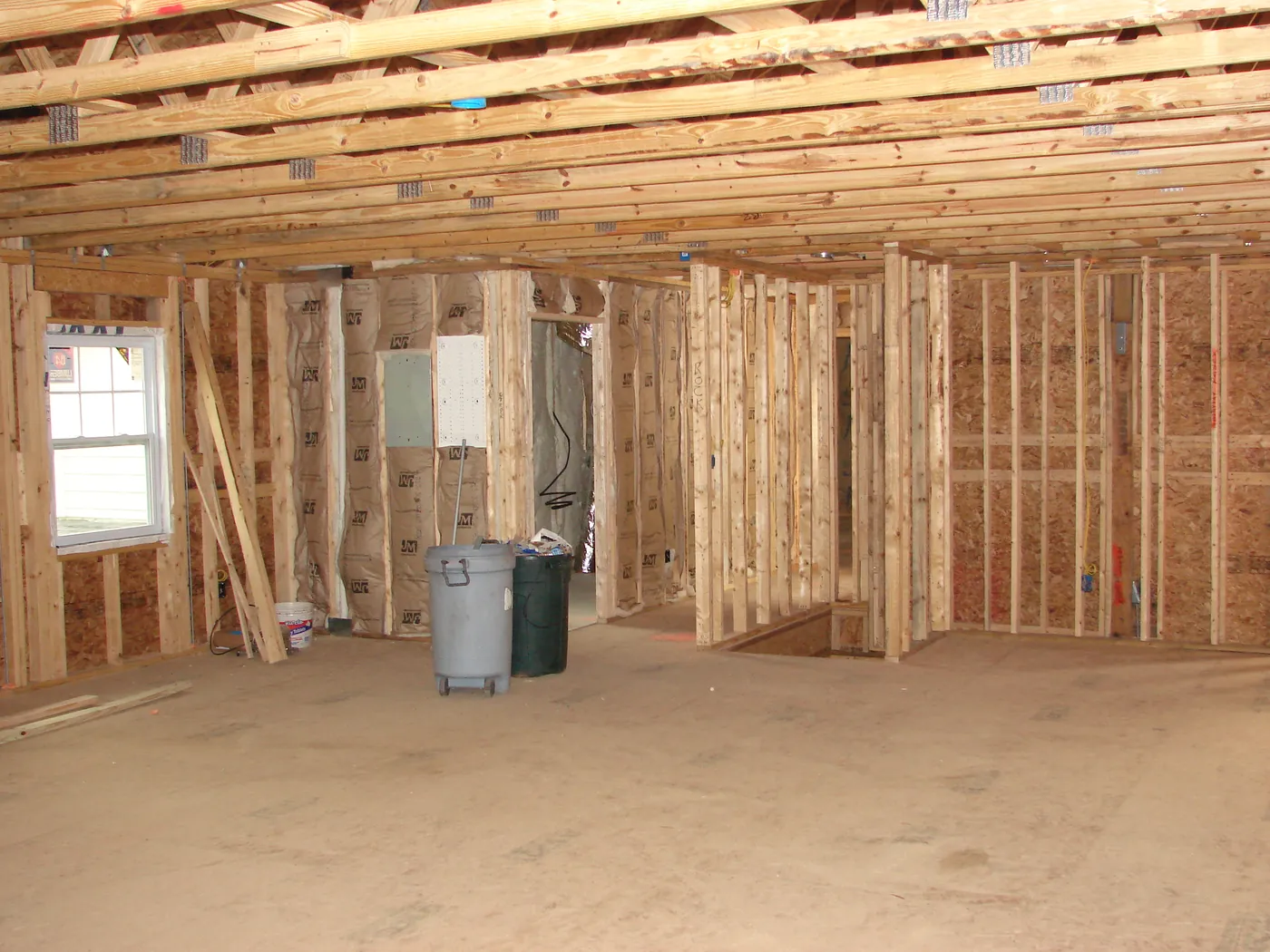 Gray electrical panel box mounted to framing in a house under construction