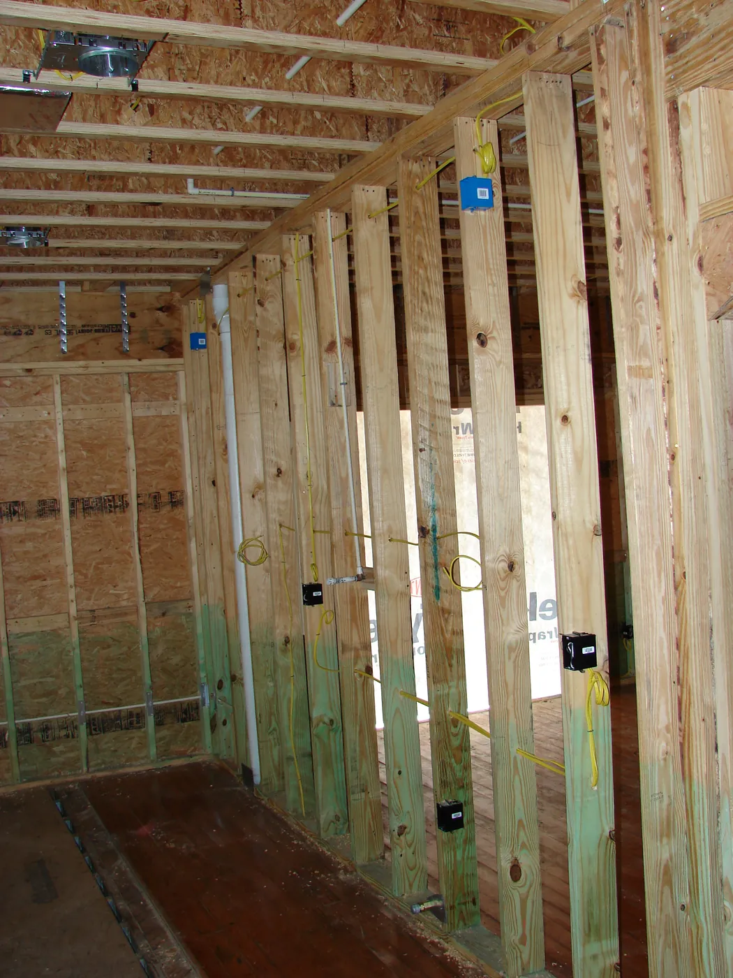 Interior framed hallway with electrical boxes and wiring roughed in on studs
