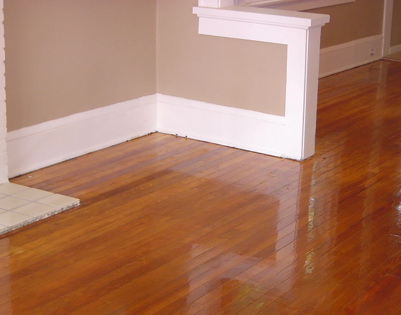 Newly painted room with clean white trim and baseboards over refinished wood flooring