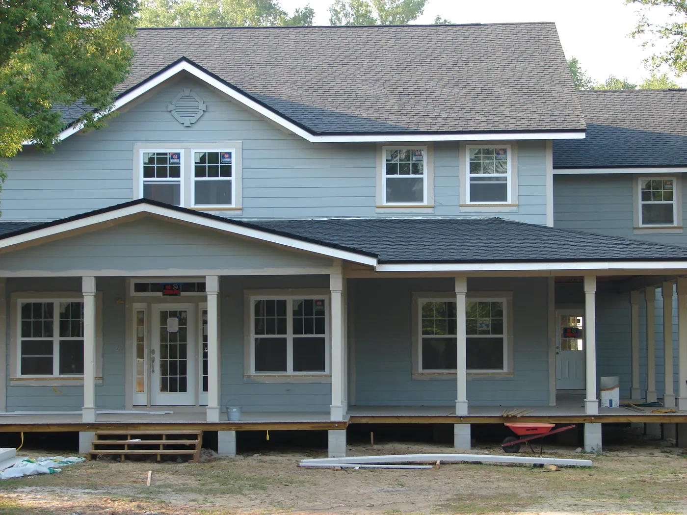 Exterior of a two-story home with freshly painted blue lap siding and white trim and porch columns