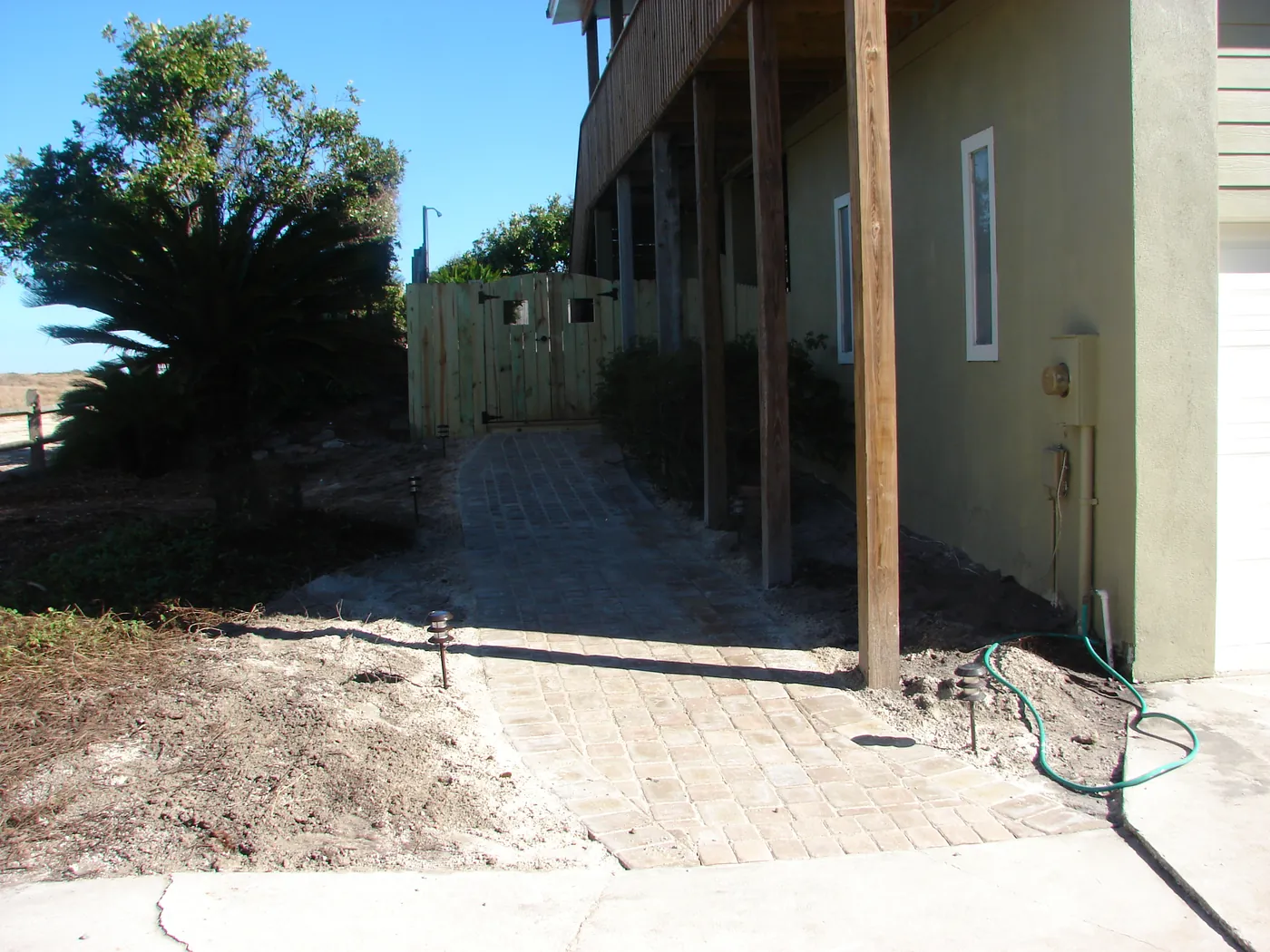 Brick paver walkway between two homes leading out toward the street