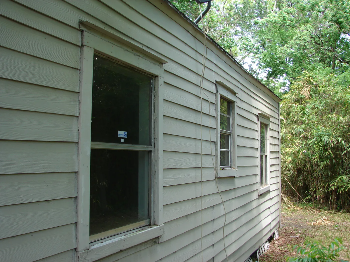 Side wall of a home with a window, showing clean pale siding after pressure washing