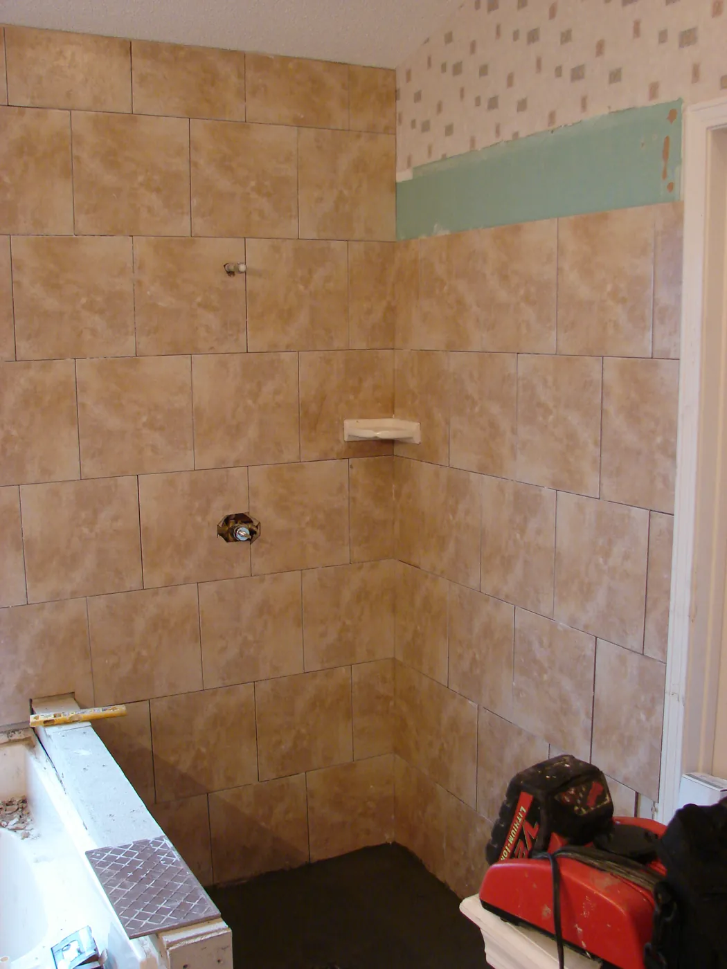 Beige ceramic tub surround with a decorative tile accent band
