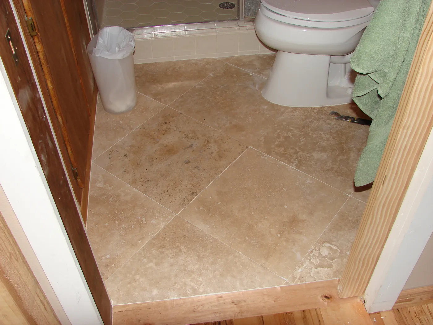 Travertine tile bathroom floor with contrasting mosaic border